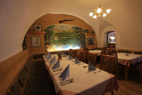 a dining room with tables and a painting on the wall at Hotel Pension Kandolf in Tamsweg