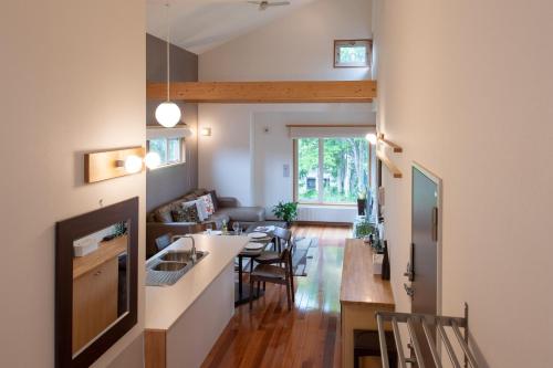 a kitchen and living room with a table and chairs at Shinsetsu in Niseko