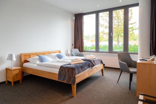 a bedroom with a bed and a large window at Hotel Vivendi in Paderborn