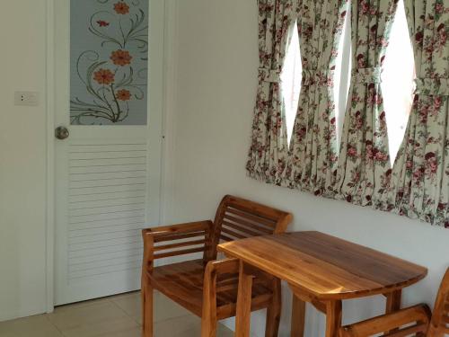 Un comedor con una mesa de madera y dos sillas. en Baan Suan Yensabai @Ayutthaya, en Phra Nakhon Si Ayutthaya