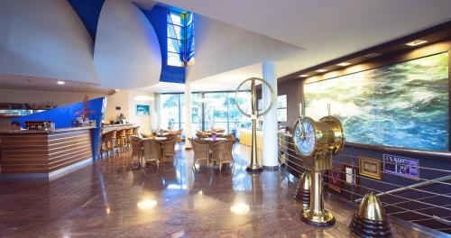 a restaurant with a bar with chairs and a clock at Miami Mar - Boutique Hotel & Restaurante in Sant Carles de la Ràpita