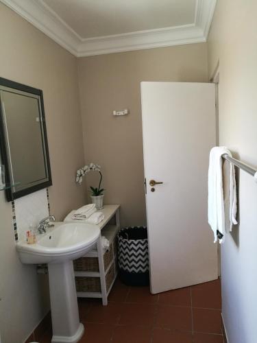 a bathroom with a sink and a mirror at Lucias Cottage in Cape Town