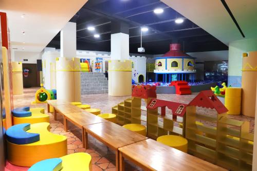 a restaurant with wooden benches and play equipment at Dusit Thani Shuangyue Bay Resort Huizhou in Huidong
