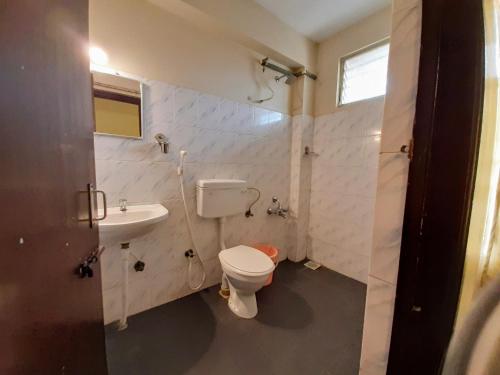 a bathroom with a toilet and a sink at Ravi Krishna Inn in Puducherry