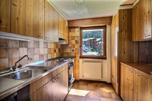 a kitchen with wooden cabinets and a sink and a window at Skirama 018 in Verbier