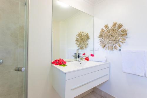 a white bathroom with a sink and a mirror at Tropicana Lagoon Apartments in Port Vila