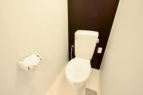a bathroom with a toilet and a roll of toilet paper at Adan hotel in Nago