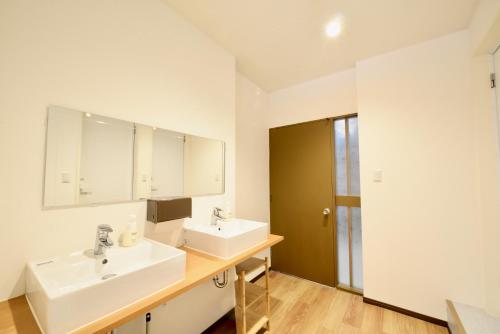 a white bathroom with two sinks and a mirror at Adan hotel in Nago