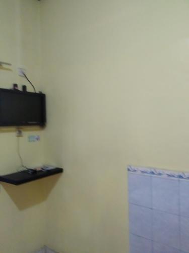 a corner of a room with a tv on a wall at Primadona Homestay in Sleman