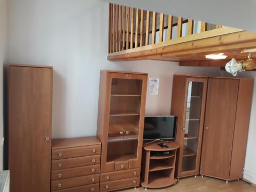 a living room with a tv and a wooden cabinet at Apartmán Pavilón D-PETER in Smokovce