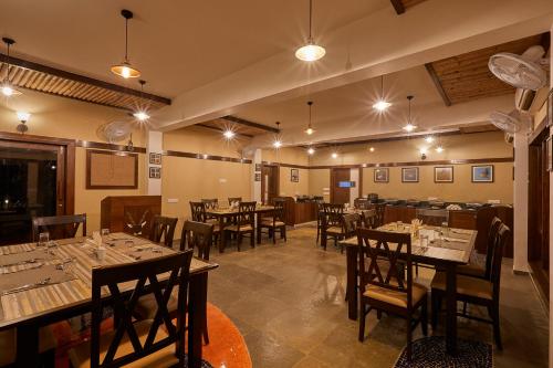 um restaurante com mesas e cadeiras num quarto em Blackbuck Safari Lodge Velavadar em Velavadar