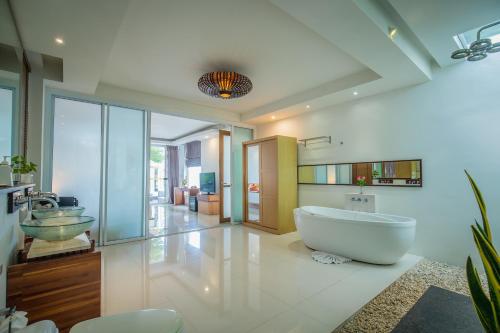 a large bathroom with a tub and a sink at KC Beach Club & Pool Villas in Chaweng