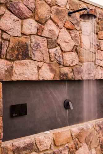 a stone wall with a water fountain in a bath room at 57 Waterberg in Welgevonden Game Reserve