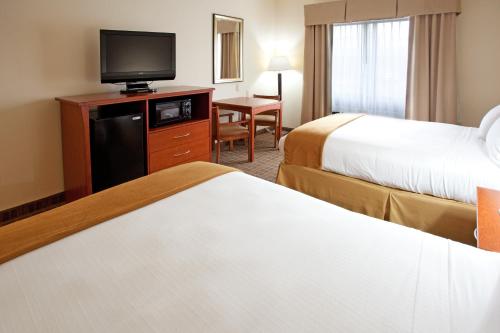 a hotel room with two beds and a flat screen tv at Holiday Inn Express & Suites - Hardeeville-Hilton Head by IHG in Hardeeville