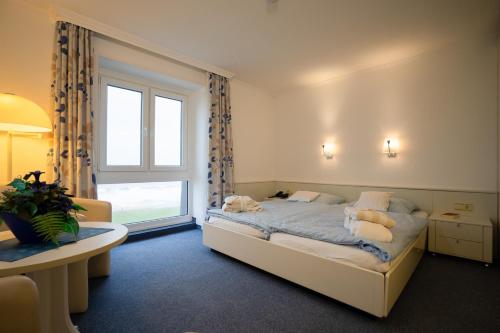 Un pat sau paturi într-o cameră la Hotels Haus Waterkant & Strandvilla Eils