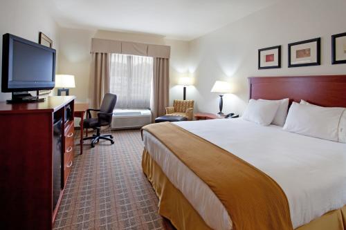 a hotel room with a bed and a flat screen tv at Holiday Inn Express & Suites - Hardeeville-Hilton Head by IHG in Hardeeville