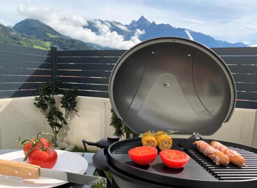 a grill with vegetables on it with a view of mountains at Easy Living Apartment Ötztal in Sautens