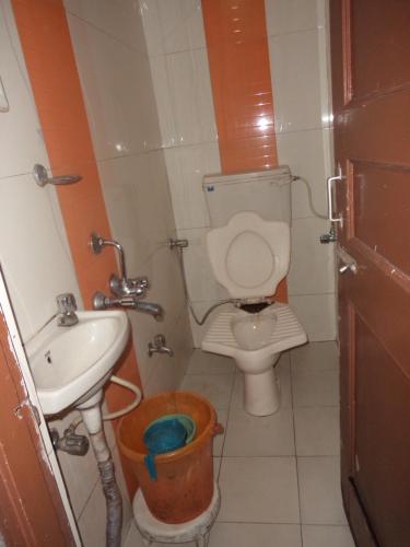 a small bathroom with a toilet and a sink at Hotel Shailmar in Mount Ābu