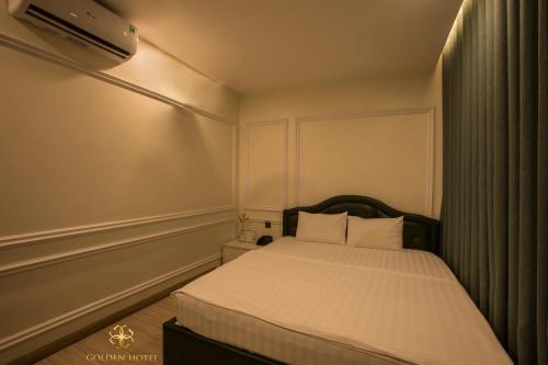 a small bedroom with a bed with white sheets at Golden Hotel in Hanoi