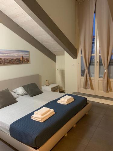 una camera da letto con un letto e due asciugamani di Nonno Pinin a Torino