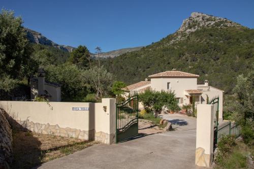 a gate to a house with a mountain in the background at Villa Foia Vella - adults only in Benichembla