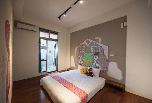 a bedroom with a bed with a painting on the wall at 安平寵物島 民宿 in Tainan