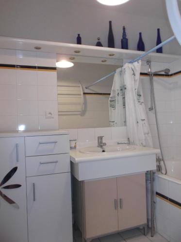 a white kitchen with a sink and a counter at résidence de la plage in Jullouville-les-Pins