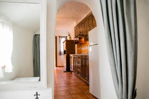 cocina con suelo de baldosa y nevera blanca en Casas Cueva Molino Fuencaliente, en Huéscar