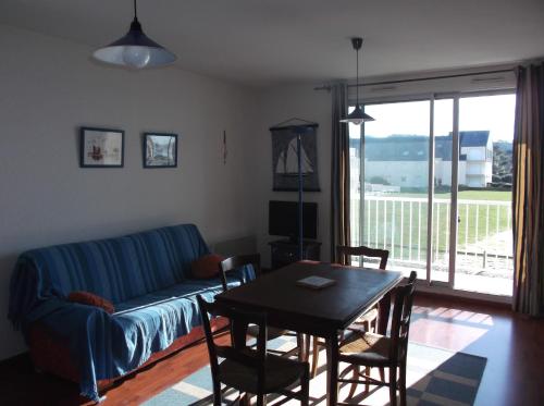 a living room with a blue couch and a table at résidence de la plage in Jullouville-les-Pins