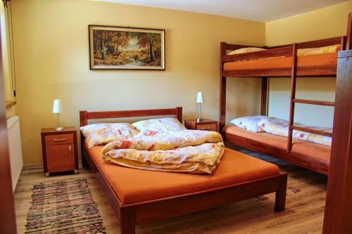 a bedroom with two bunk beds and two tables at Domki Beskid in Rzyki