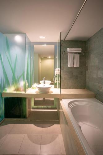 a bathroom with a sink and a bath tub at EDEN Hotel Kuta Bali in Kuta