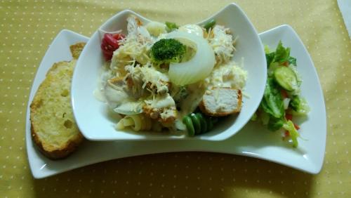 a plate of food with a salad and a sandwich at The Red Hut Inn in Belize City