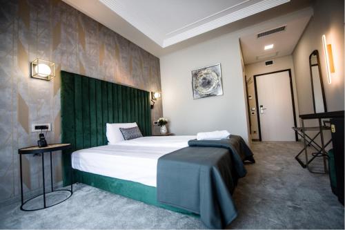 a bedroom with a large bed with a green headboard at Nora Prestige in Timişoara