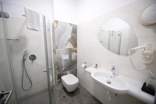 a bathroom with a shower and a toilet and a sink at Nora Prestige in Timişoara