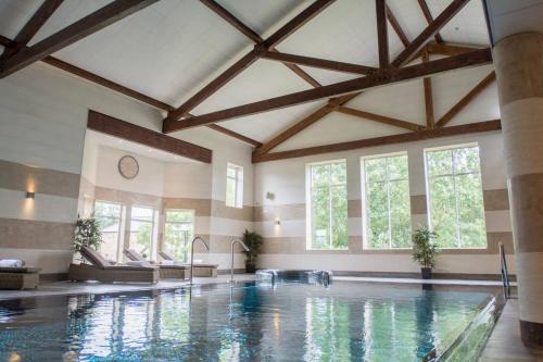 a swimming pool in a large room with windows at Dunlin in Belford