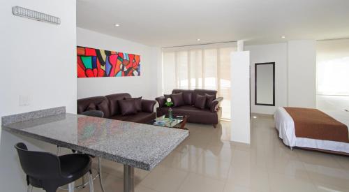 a kitchen and living room with a bed and a table at 122 Plaza Apartahotel in Bogotá