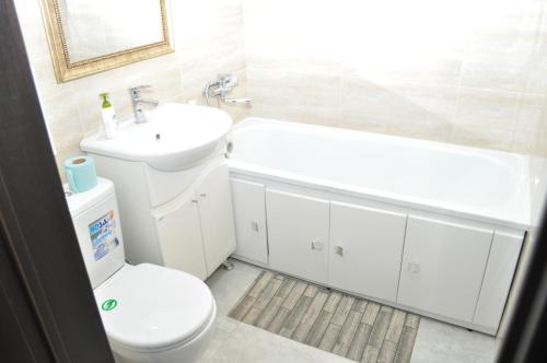 a white bathroom with a toilet and a sink at Apartments in the heart of Kursk on Radischeva street in Kursk