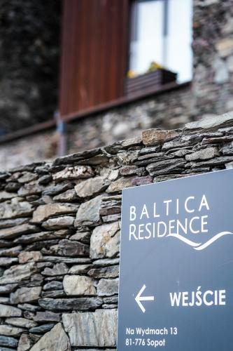 a sign on the side of a stone wall at Baltica Residence in Sopot