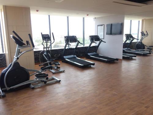 a gym with a row of treadms and elliptical machines at Regenta Central RS Chennai OMR SIPCOT in Chennai