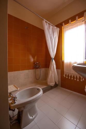 a bathroom with a tub and a toilet and a window at Casale Il Trecento in Castiglion Fiorentino