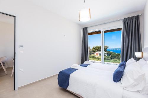 a bedroom with a bed and a large window at Sun and Sea Plus Resort in Plaka