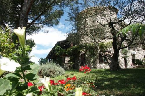 een oud stenen huis met bloemen in de tuin bij Lovely place in Passignano sul Trasimeno