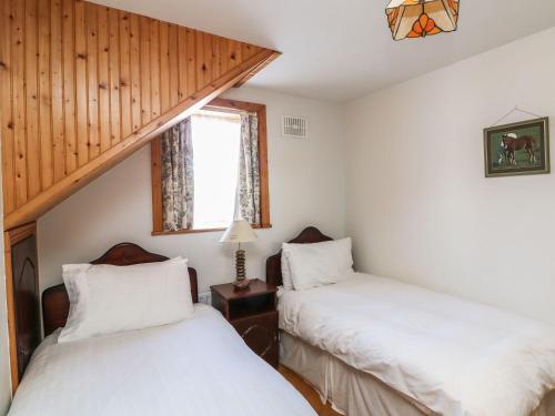 two twin beds in a room with a window at Seascape in Fethard on Sea