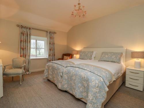 a bedroom with a bed and a chair and a window at The Nook Bank Newton in Bell Busk