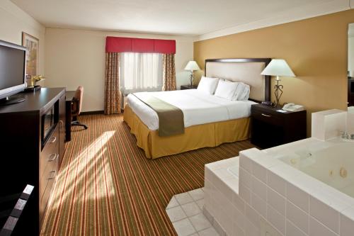 a hotel room with a bed and a tub at Baymont by Wyndham Litchfield in Litchfield