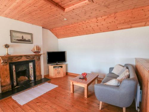 a living room with a couch and a fireplace at Seascape in Fethard on Sea