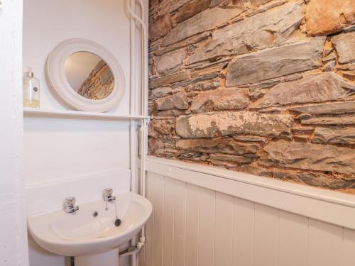 a bathroom with a sink and a stone wall at The Pink House in Isle of Whithorn