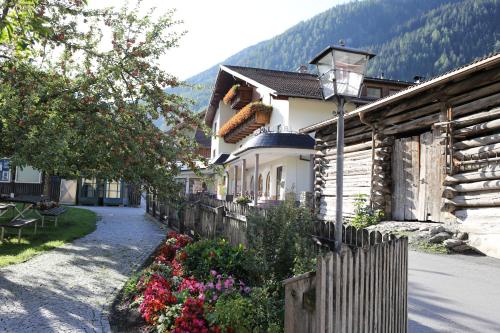 a house with a fence and flowers in front of it at Pension Gabl in Pfunds