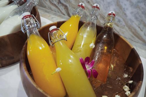 a wooden bowl filled with different colored glass bottles at Eleven Hotel Bangkok Sukhumvit 11 in Bangkok