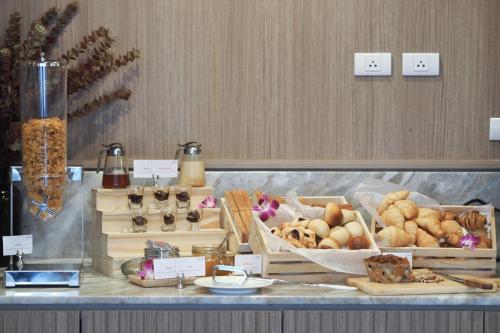 a buffet with different types of bread and pastries at Eleven Hotel Bangkok Sukhumvit 11 in Bangkok